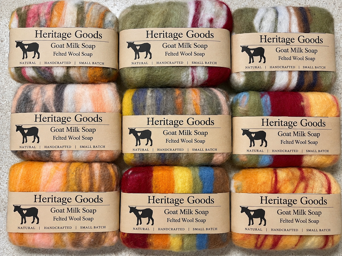 Eight skeins of Heritage Goods felted wool soap bars arranged in a 2x4 grid, showing a variety of colorful marled wool blends including orange, yellow, red, blue, green, and cream.